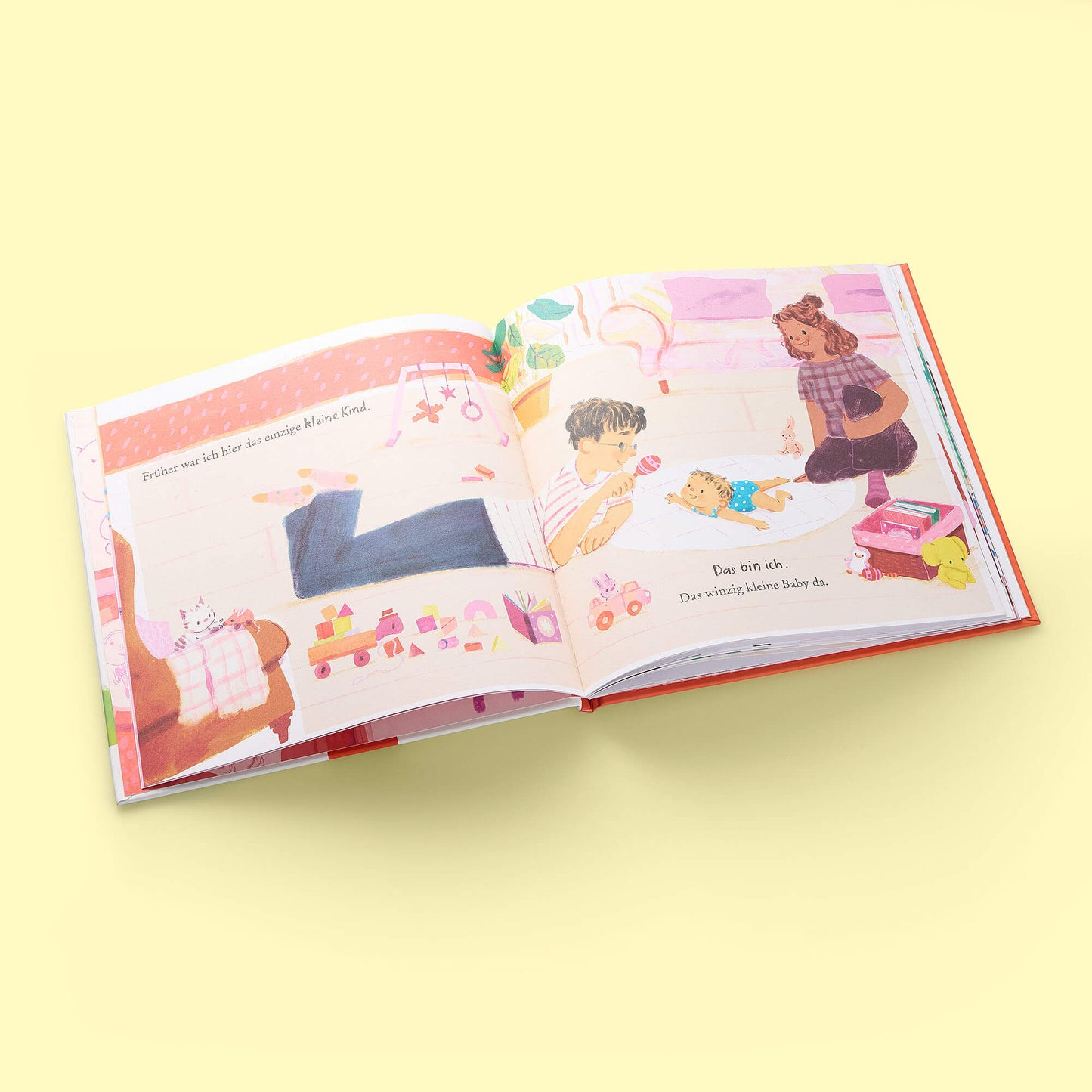 Ein aufgeschlagenes Exemplar von "Auch große Geschwister sind noch klein" aus dem Zuckersüß Verlag liegt auf einer blassgelben Fläche und zeigt farbenfrohe Illustrationen von Kindern, älteren Geschwistern und Erwachsenen, die im Haus spielen, mit deutschem Text auf beiden Seiten.